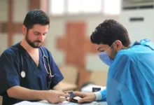 يعاين الطبيب مناف الجاسم مريضه الشاب بمشفى المجتهد بدمشق