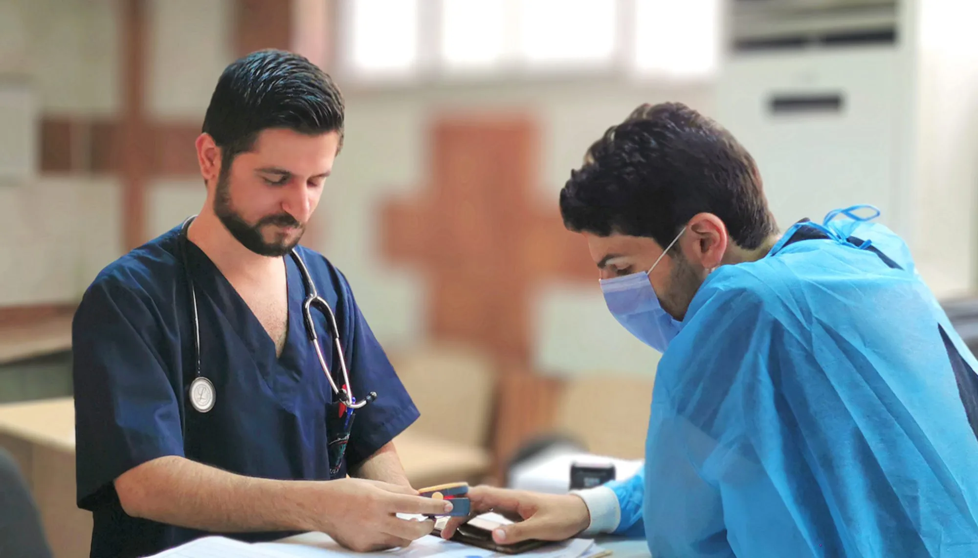 يعاين الطبيب مناف الجاسم مريضه الشاب بمشفى المجتهد بدمشق